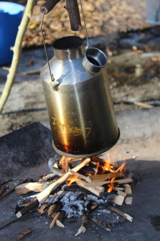 Boiling water on the camp fire to make hot chocolate.