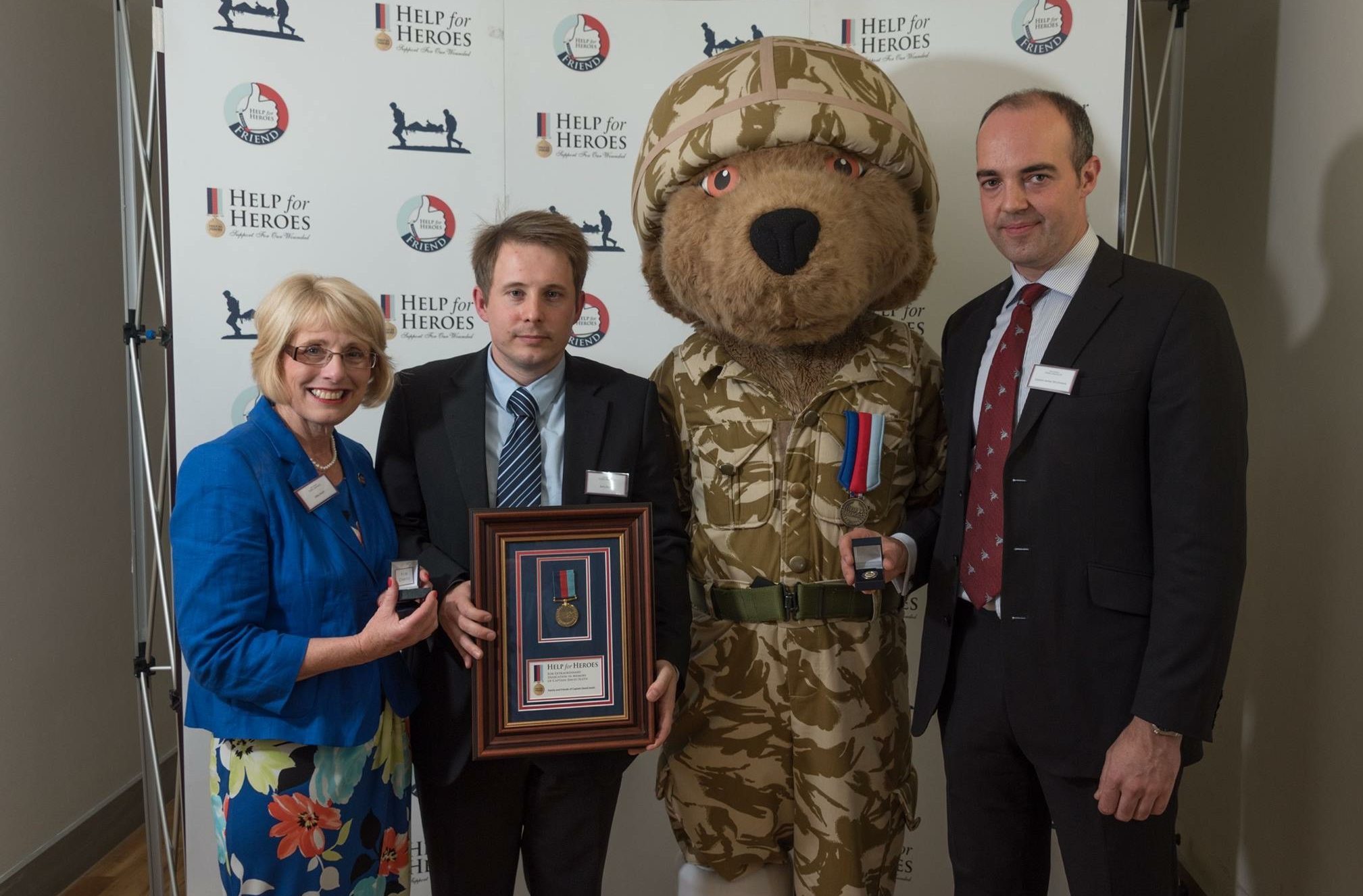 Davids mum Libby, brother Gary and his friend Captain James Walker-McClimens collect the award