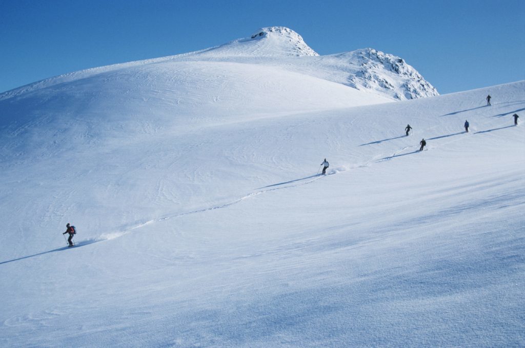 Skiers going downhill near Whistler, British Columbia.
