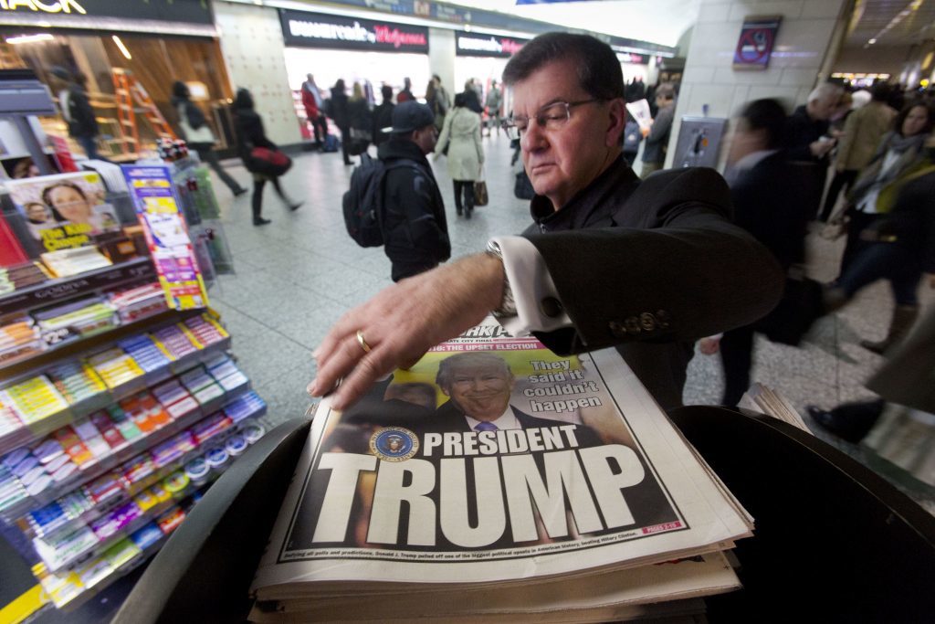 A man reaches for the New York Post newspaper featuring president-elect Donald Trump's victory,