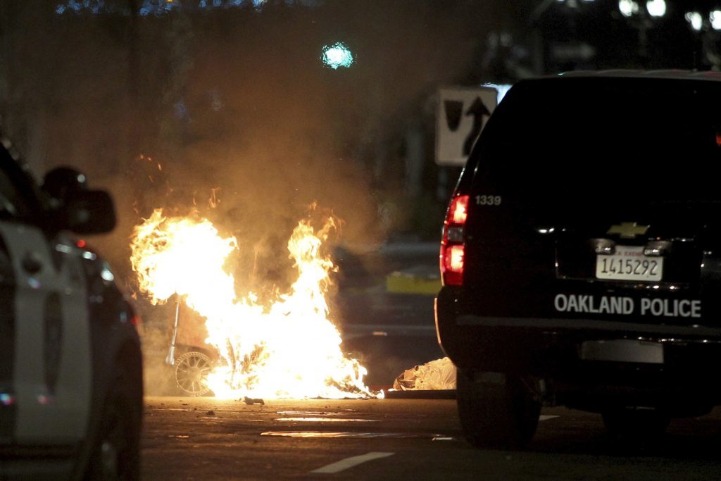 A trash fire burns during protests in Oakland, California
