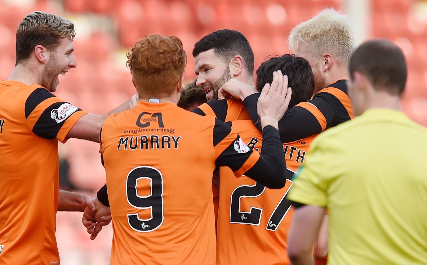 Mark Durnan is mobbed by his United teammates.