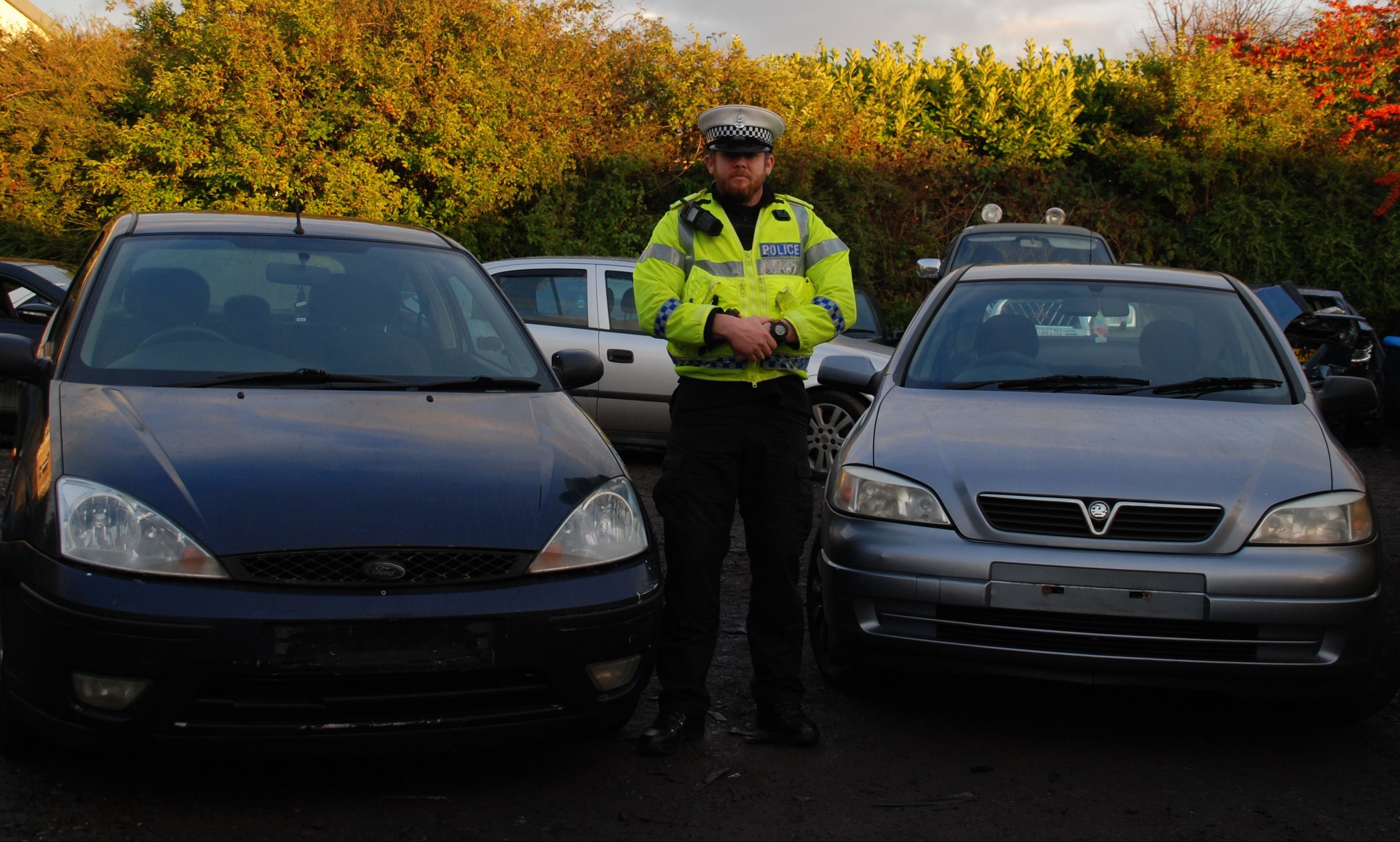 PC Chris McElwhee with two seized vehicles.
