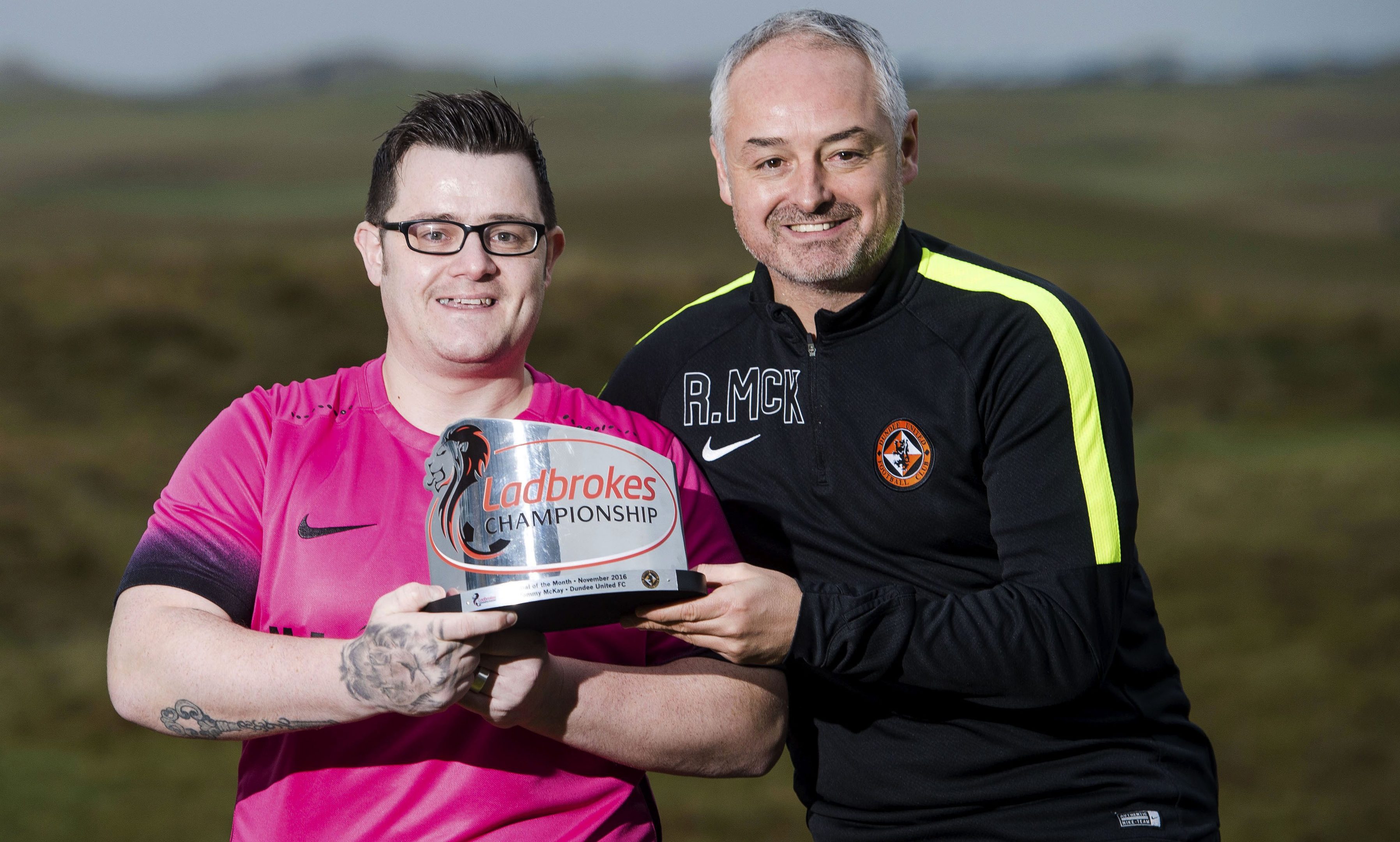 Dundee United manager Ray McKinnon presents the Goal of the Month trophy to Tommy McKay.