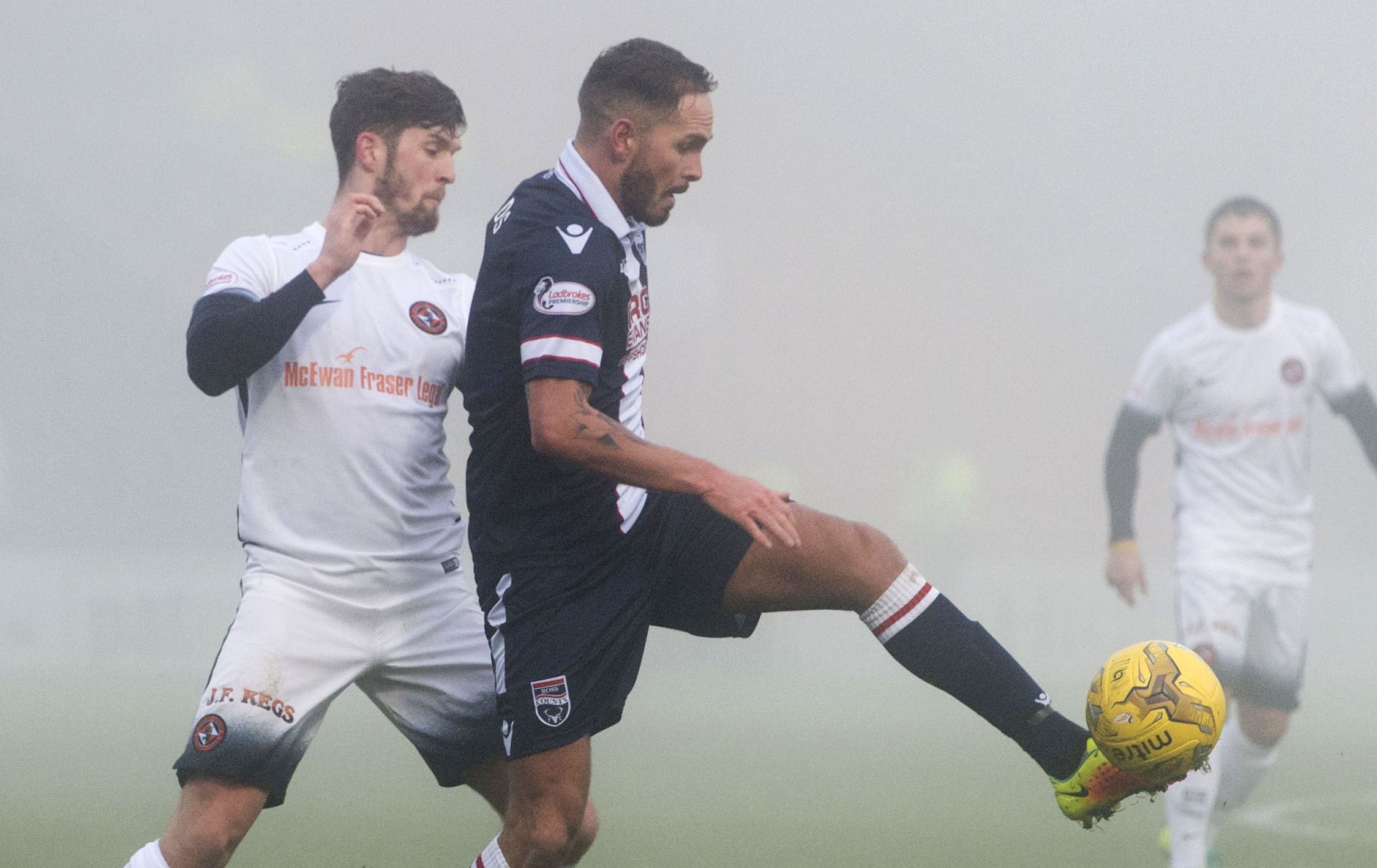 Stewart Murdoch competes with Ross County's Martin Woods.