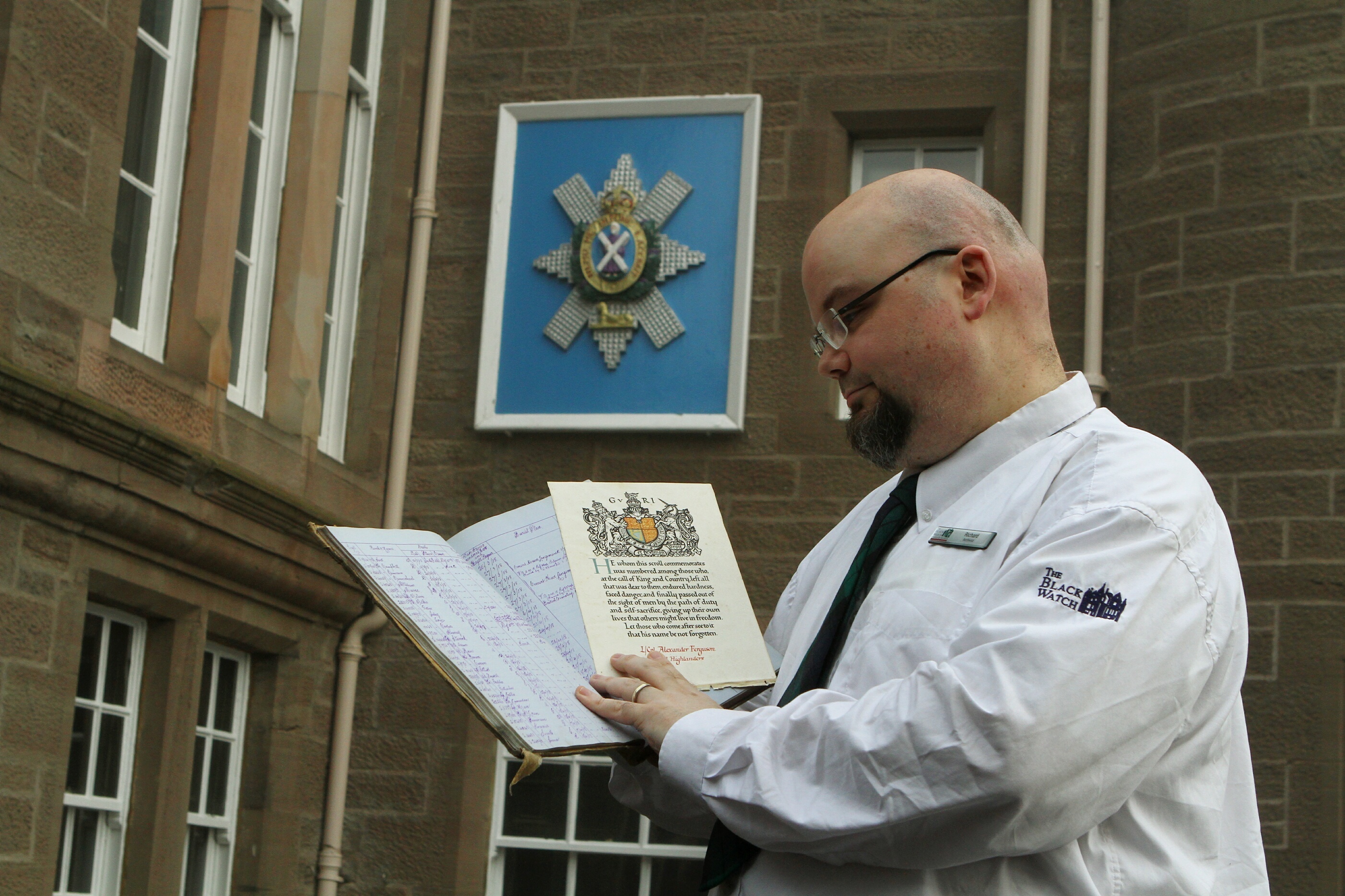 Richard McKenzie, Archivist at the Black Watch Museum, holding  the Burial Book of the 1st Battalion Black Watch and the Scroll Of Honour from L.Cpl. Alexander Ferguson of the Royal Highlanders.