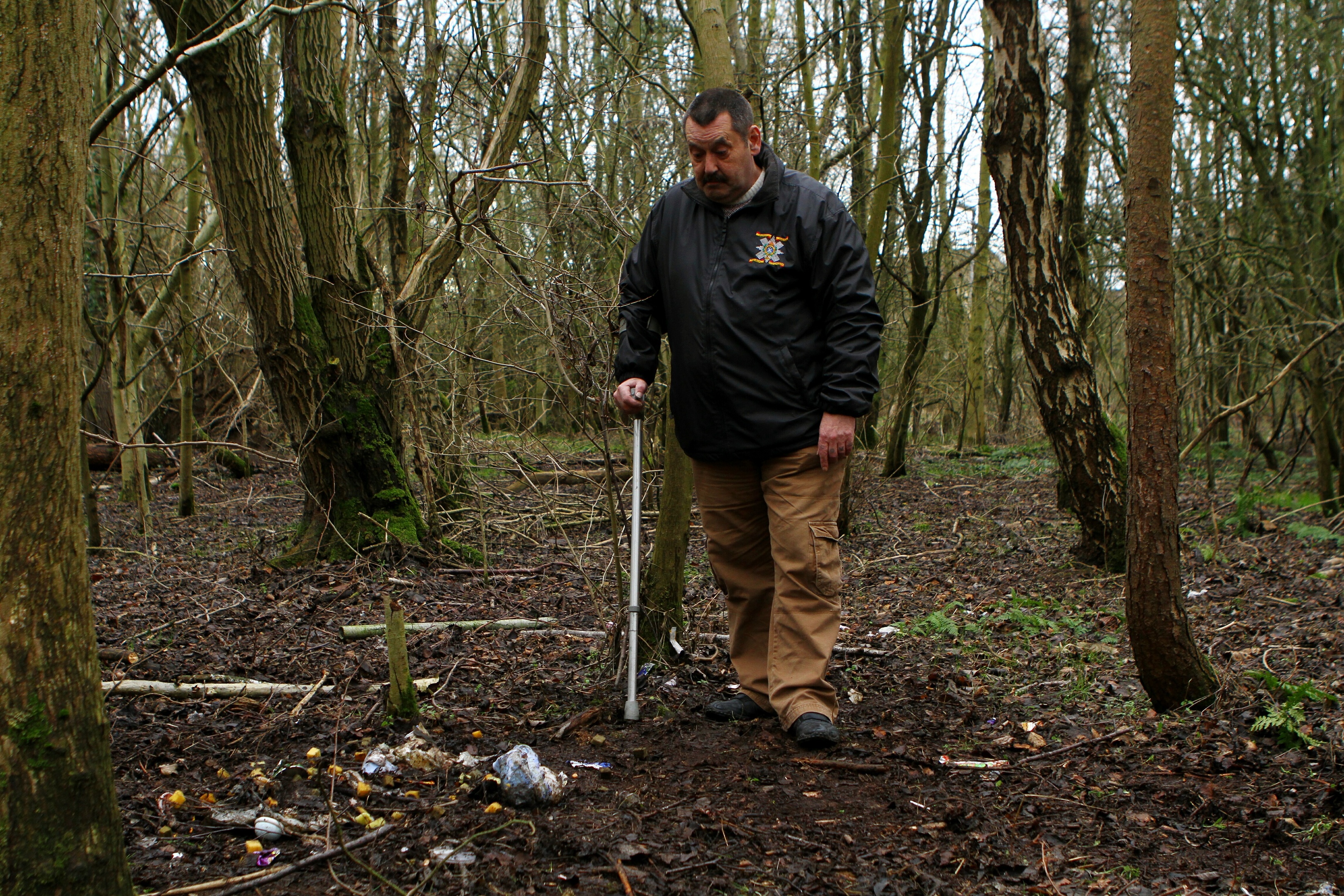 Mr Scobie examines the flytipping in the woodland near Brodie Court.