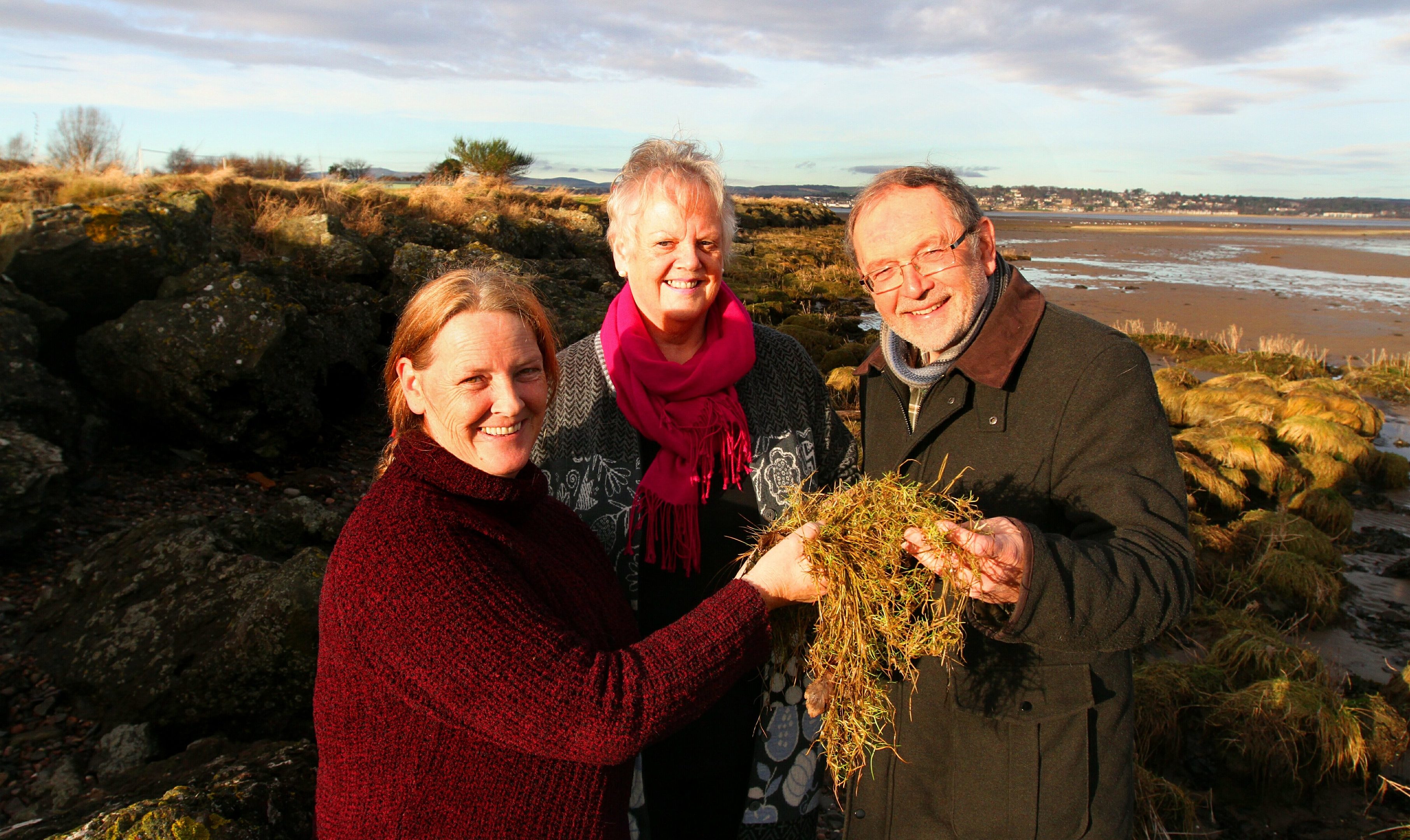 Picture shows planting of salt marsh plants at Tayport Common to create a natural flood defence. Claire Maynard, of St Andrews University, is alongside local Councillors Maggie Taylor and Tim Brett.