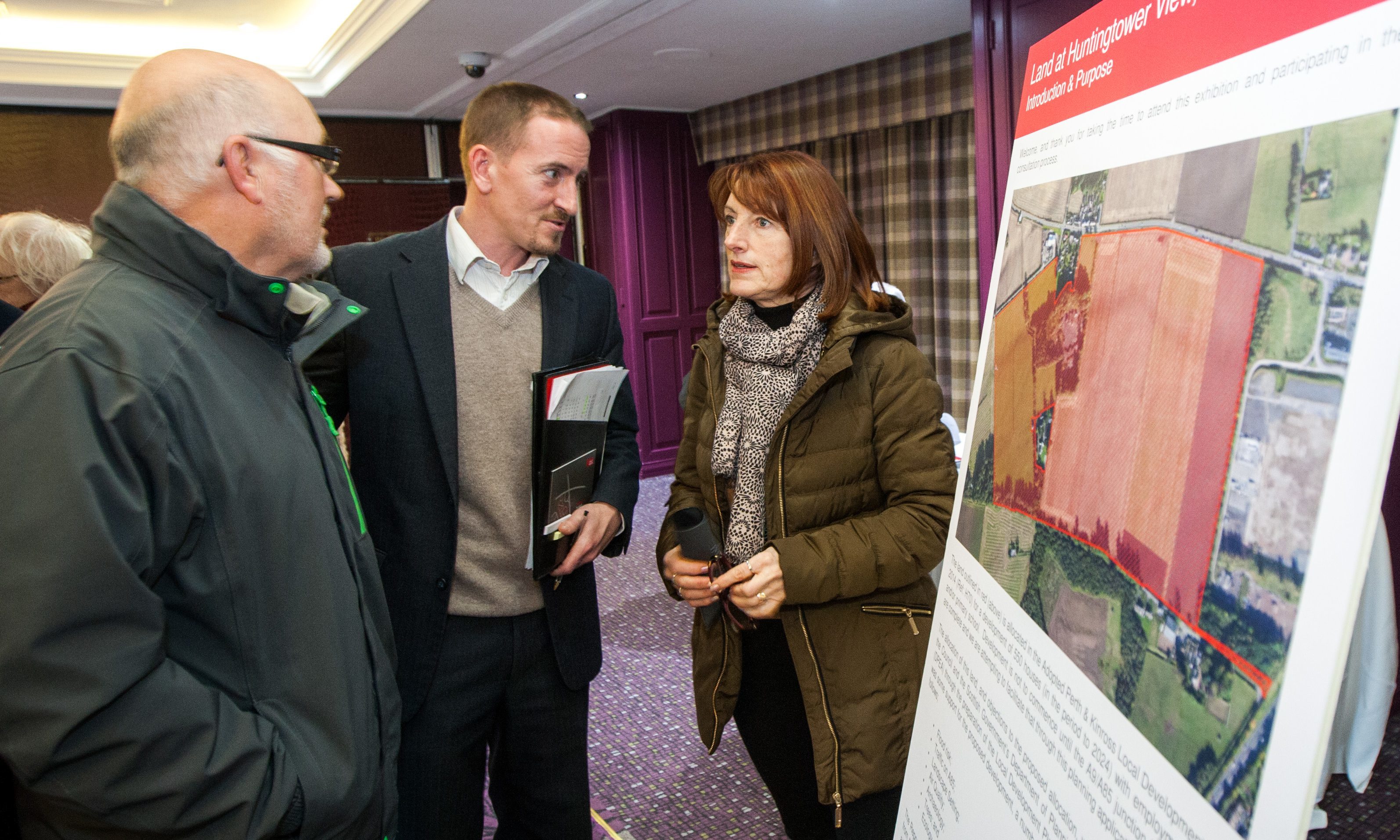 Strutt Parker hold an public exhibition regarding new homes planned for the area. Picture shows John Wright (centre, from Strutt Parker) alongside local residents Geoff and Viv Quigley.