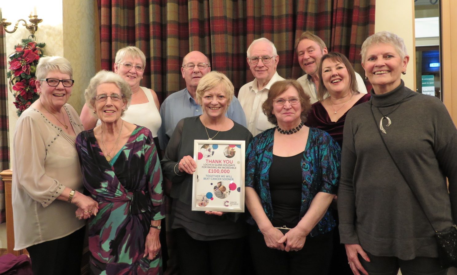 Dorothy Rodger, local fundraising manager for Cancer Research UK presents guests and staff at Lochs & Glens’ Loch Tummel Hotel with a certificate to thank them for raising £100,000 to help beat cancer sooner.