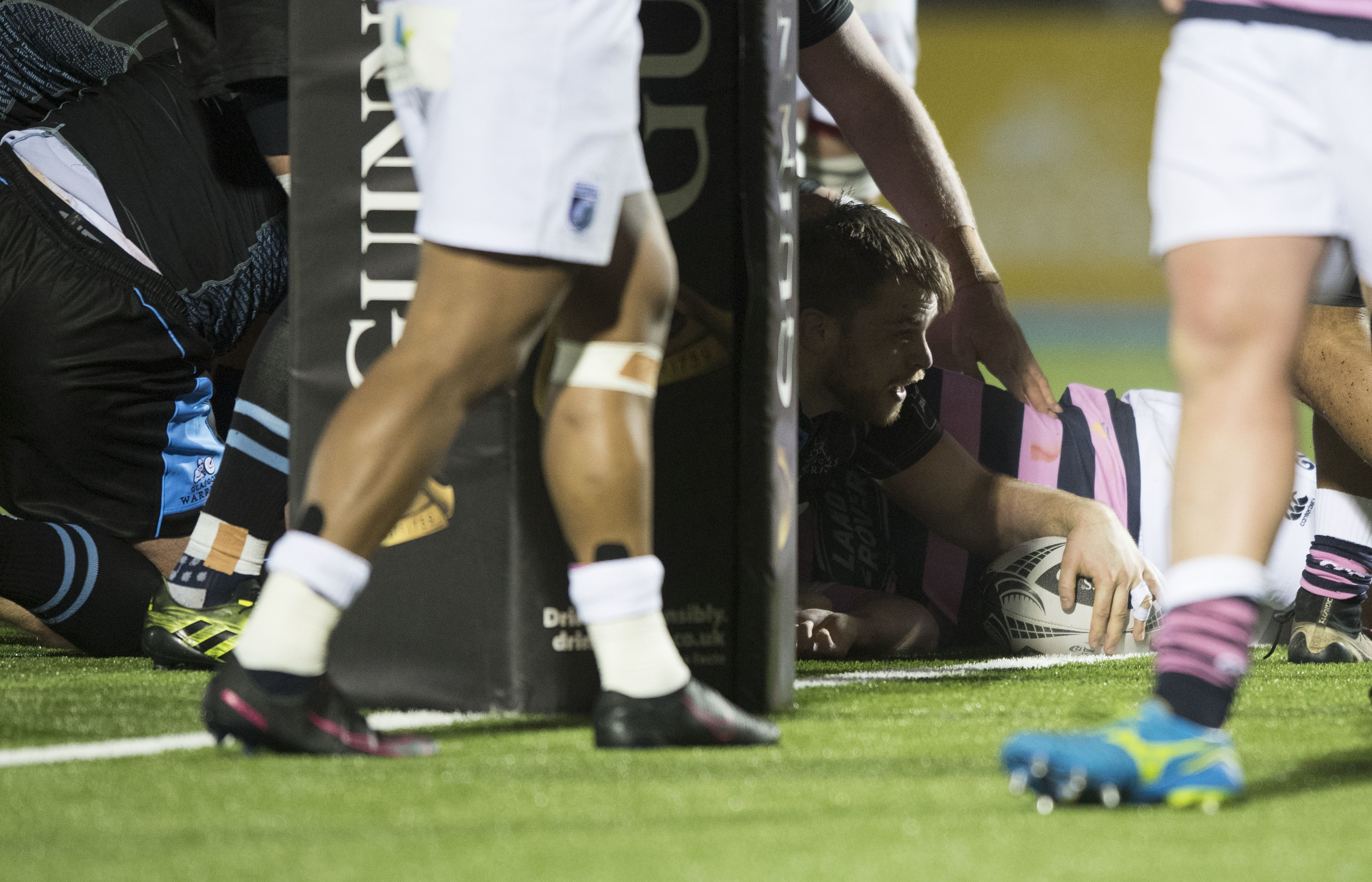 Pat MacArthur squeezes through to score Glasgow's opening try.