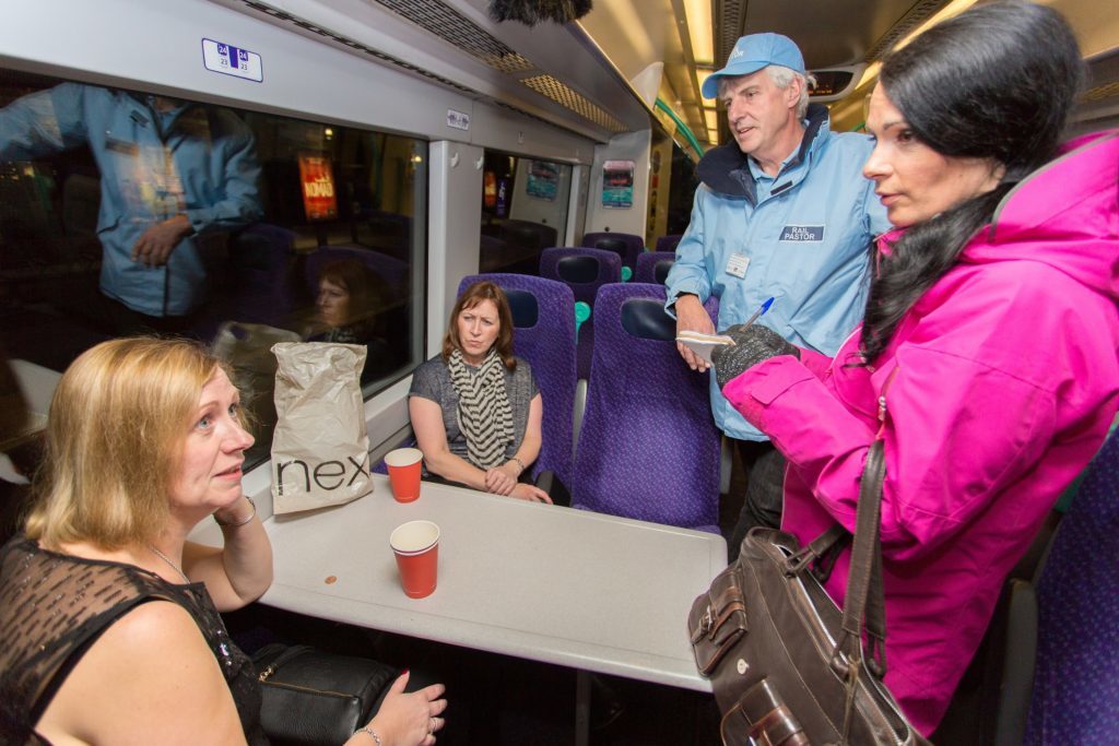 Gayle and rail pastor Alan Kimmitt speak to passengers Marie Joyce and Gillian Gibson as they head to a party.