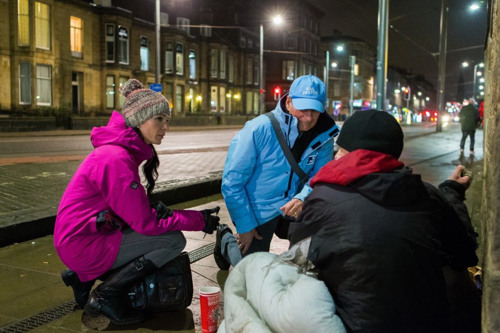 Gayle Ritchie and Moss Barclay speak to homeless man Colin Todd as he settles down for the night.