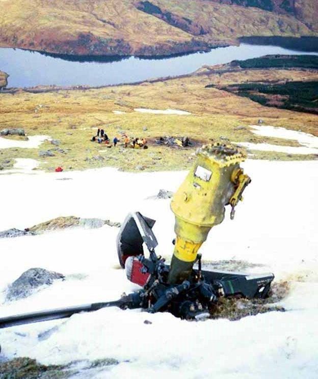 The wreckage of the helicopter lies in the snow.