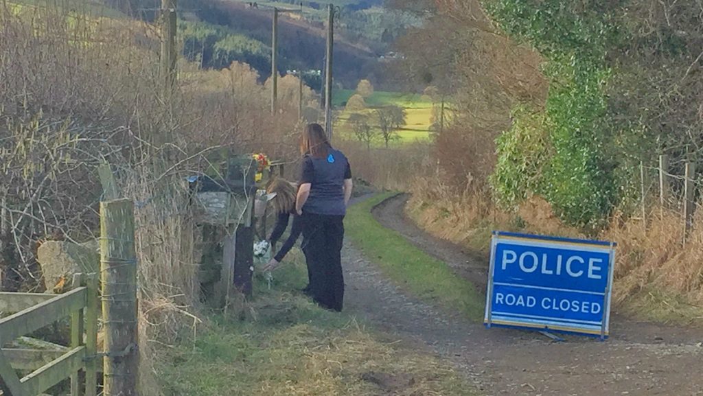 Two women lay flowers and a Peppa Pig teddy at the property on Monday.