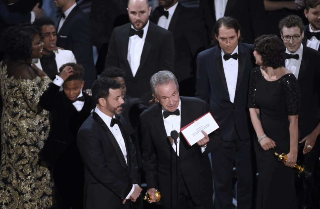 Presenter Warren Beatty shows the envelope with the actual winner for best picture as host Jimmy Kimmel, left, looks on at the Oscars on Sunday,
