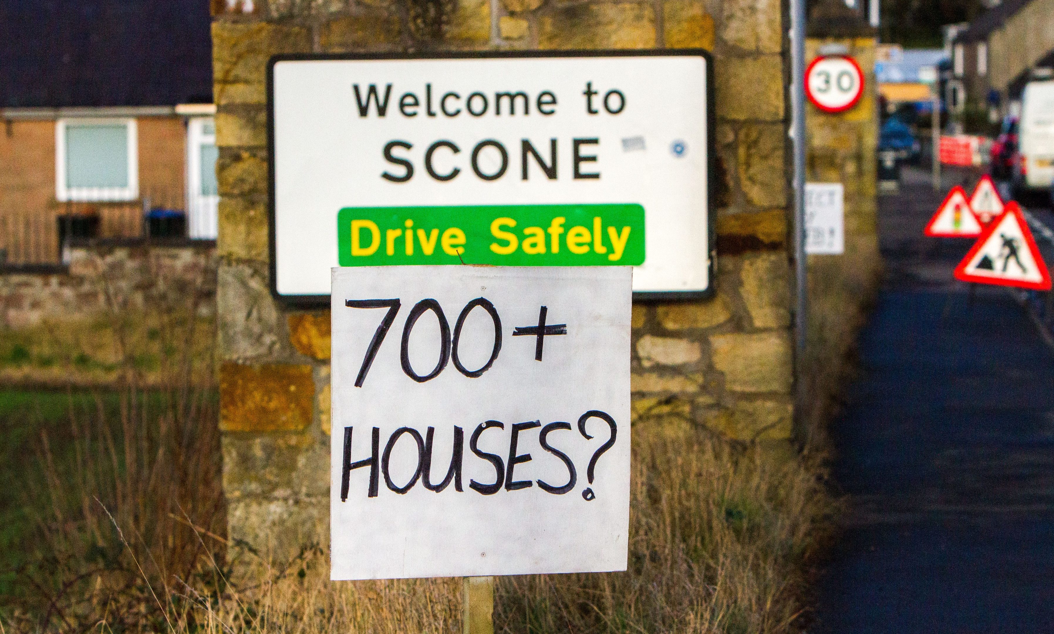 Protesters install signs at the roadside in Scone.