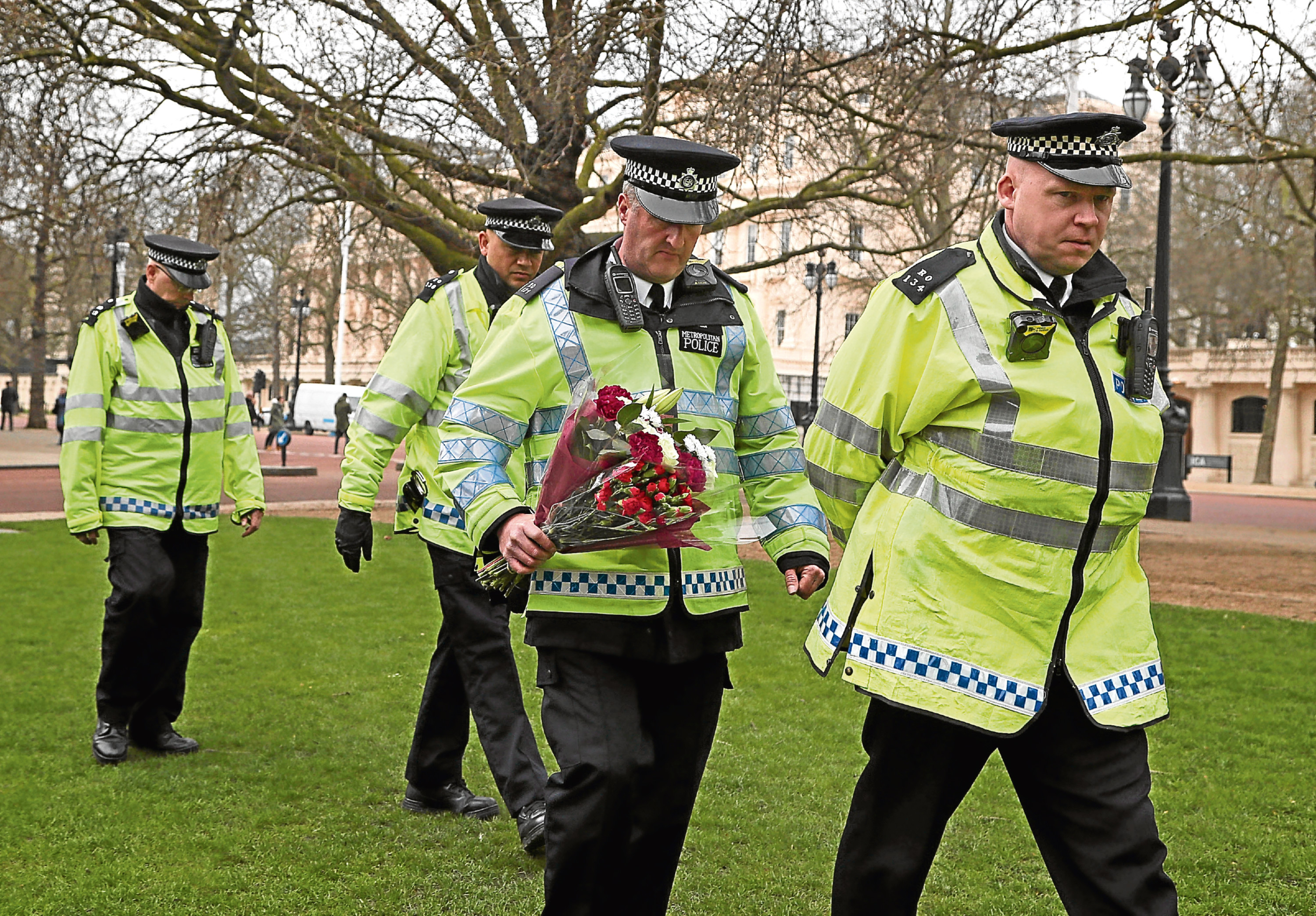 Officers prepare to lay floral tributes at the National Police Memorial in London. Picture: PA.