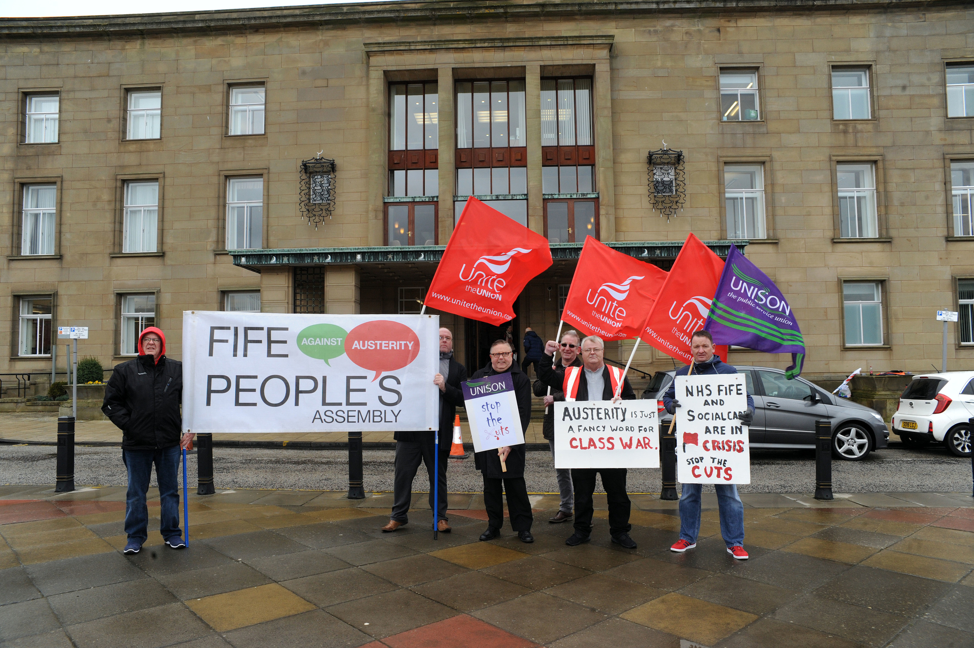 A small group of anti-cuts protesters staged a noisy protest outside the meeting.