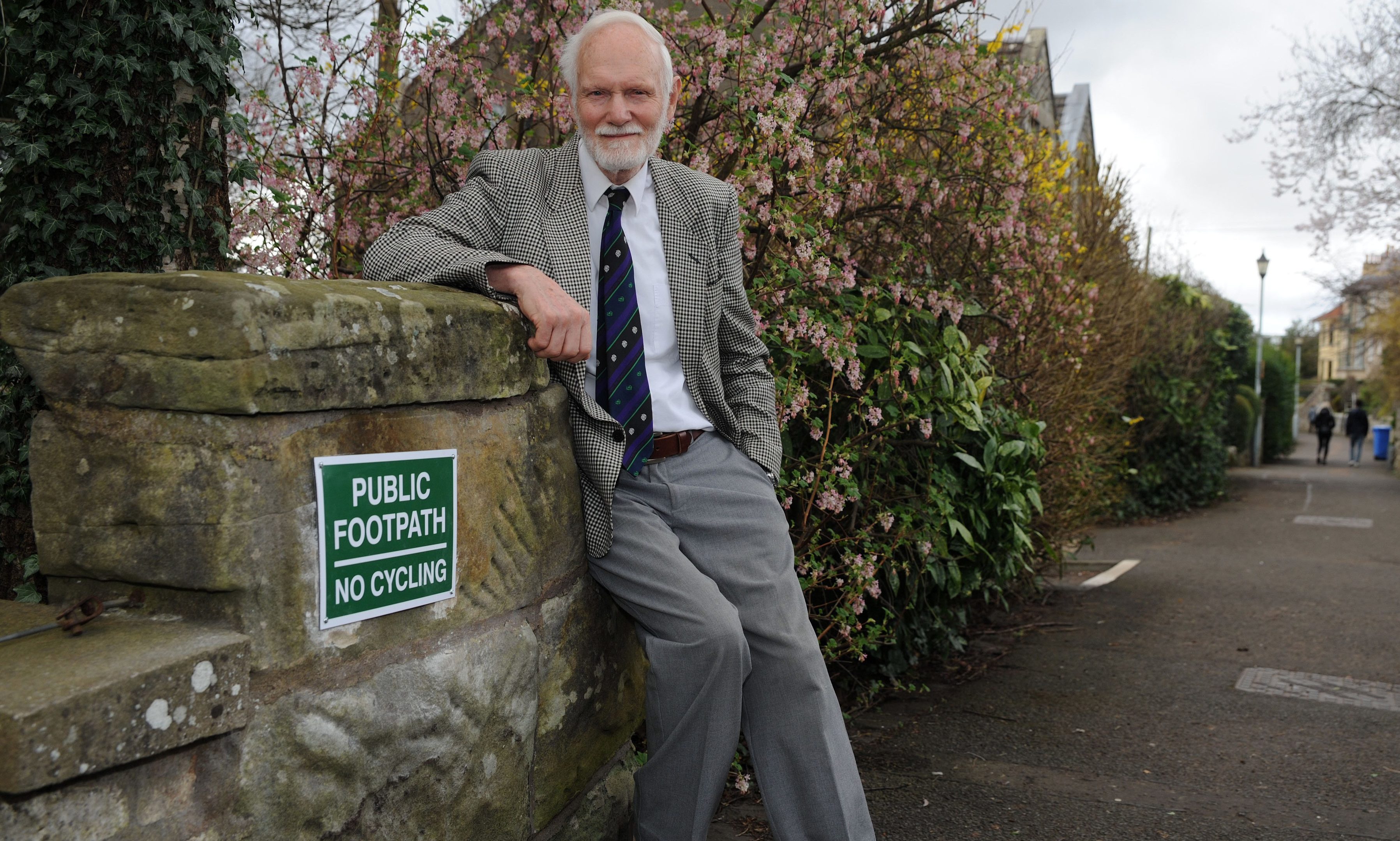 David Middleton of Lade Braes Walk in St Andrews next to one of his signs.