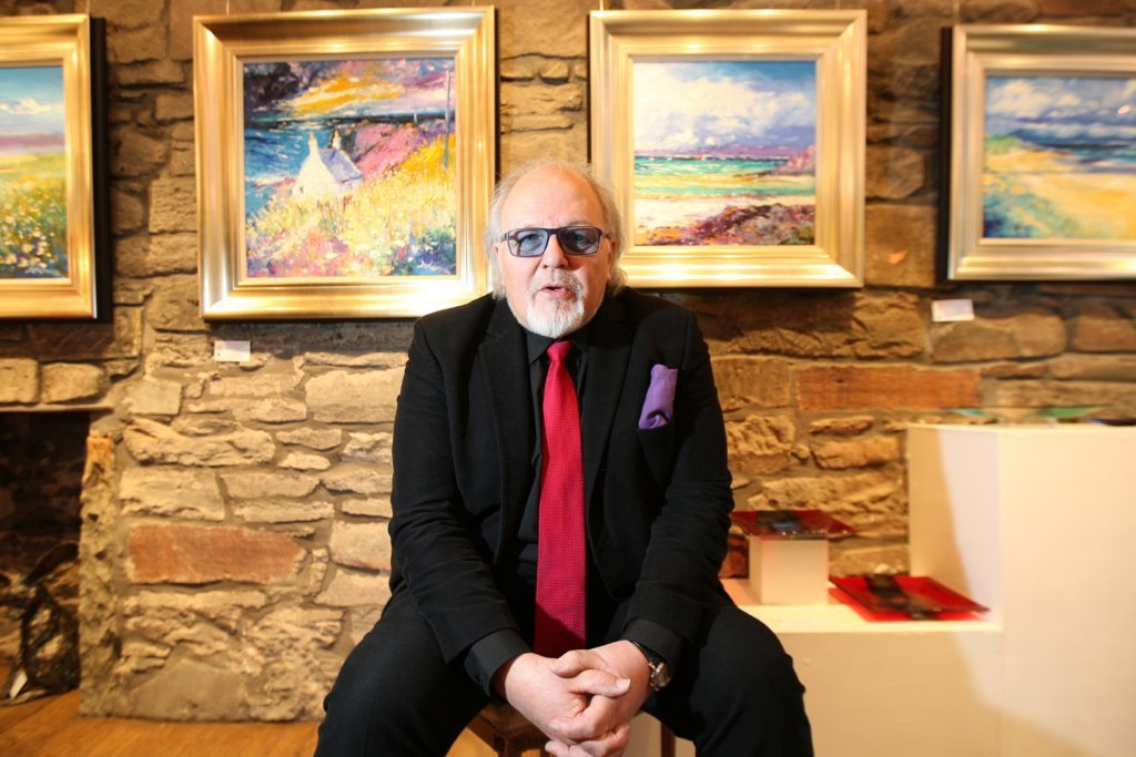 Jolomo with some of his artwork at Dundee's Gallery Q.