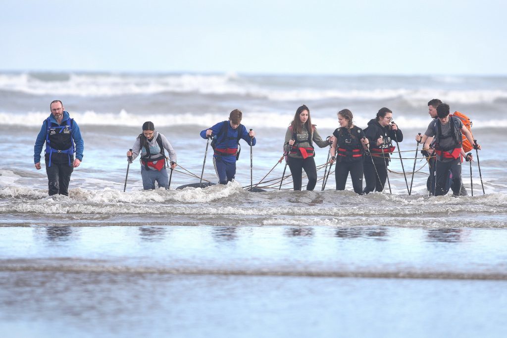 The Polar Academy team walking into the chilly North Sea with their tyres.