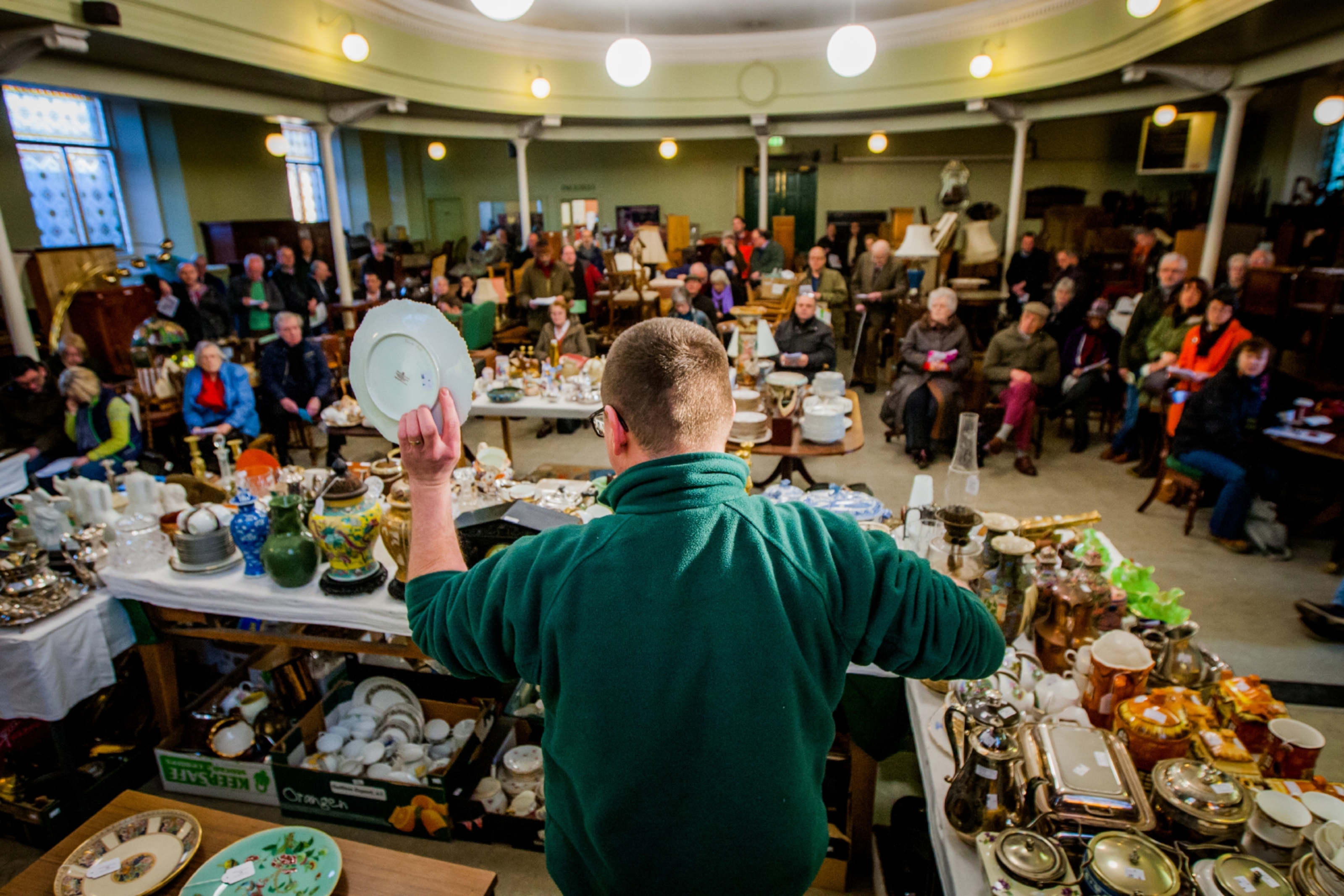 Staff displaying items to bidders at Lindsay Burns and Company in Perth.