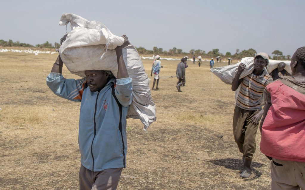  South Sudanese men carry food distributed by the World Food Programme in Leer County Southern Leich State in South Sudan where millions are on the brink of starvation. What difference would Scottish independence make to them?