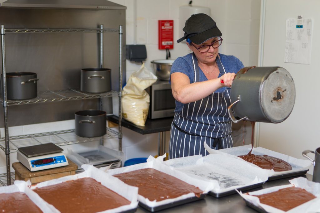 Staff member Eileen Dall pouring the fudge.