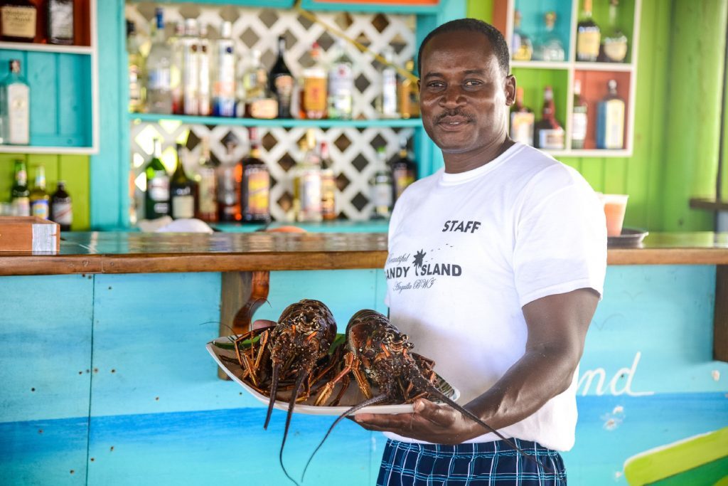 Photo of a waiter serving fresh lobster at Sandy Island's restaurant. 