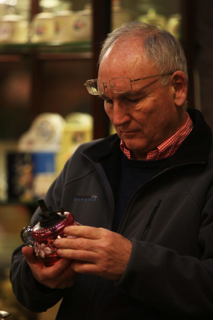 A potential bidder inspects a piece of glassware at Curr and Dewar.