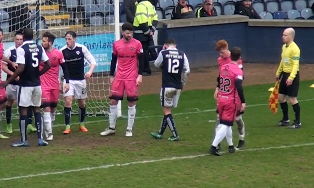 Ross Matthews (No.12) holds his head after being struck by a coin.