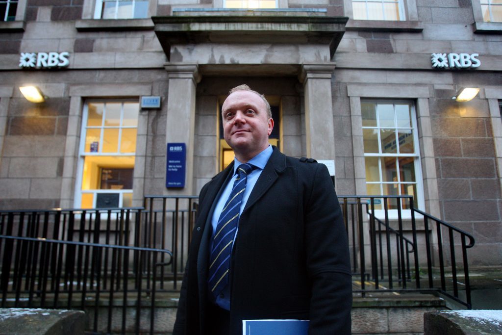 DS Murray Coull outside the Kirrie bank during an appeal for information.