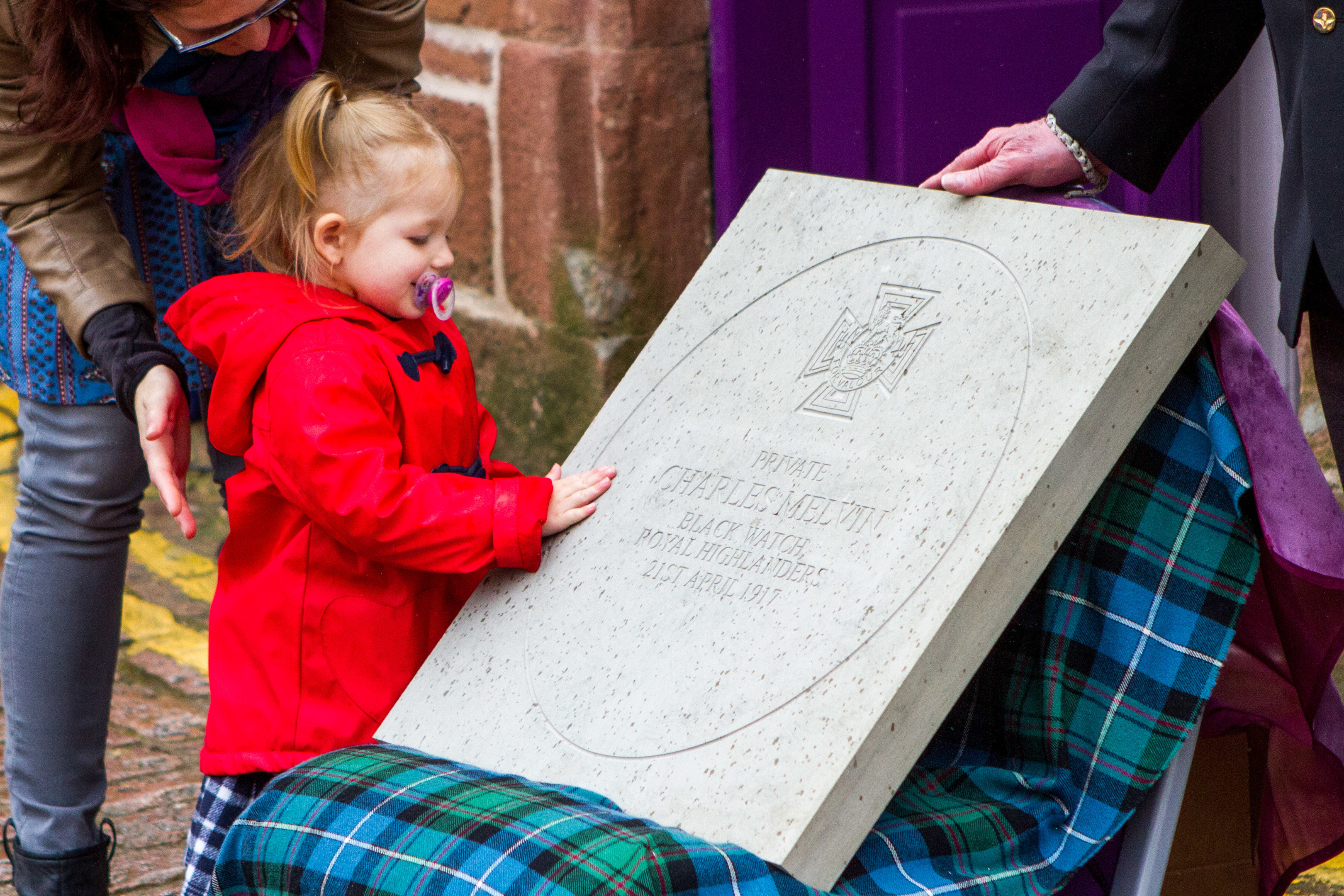 Kirby Melvin with the stone commemorating her great-great-great-uncle Pte Charles Melvin VC.