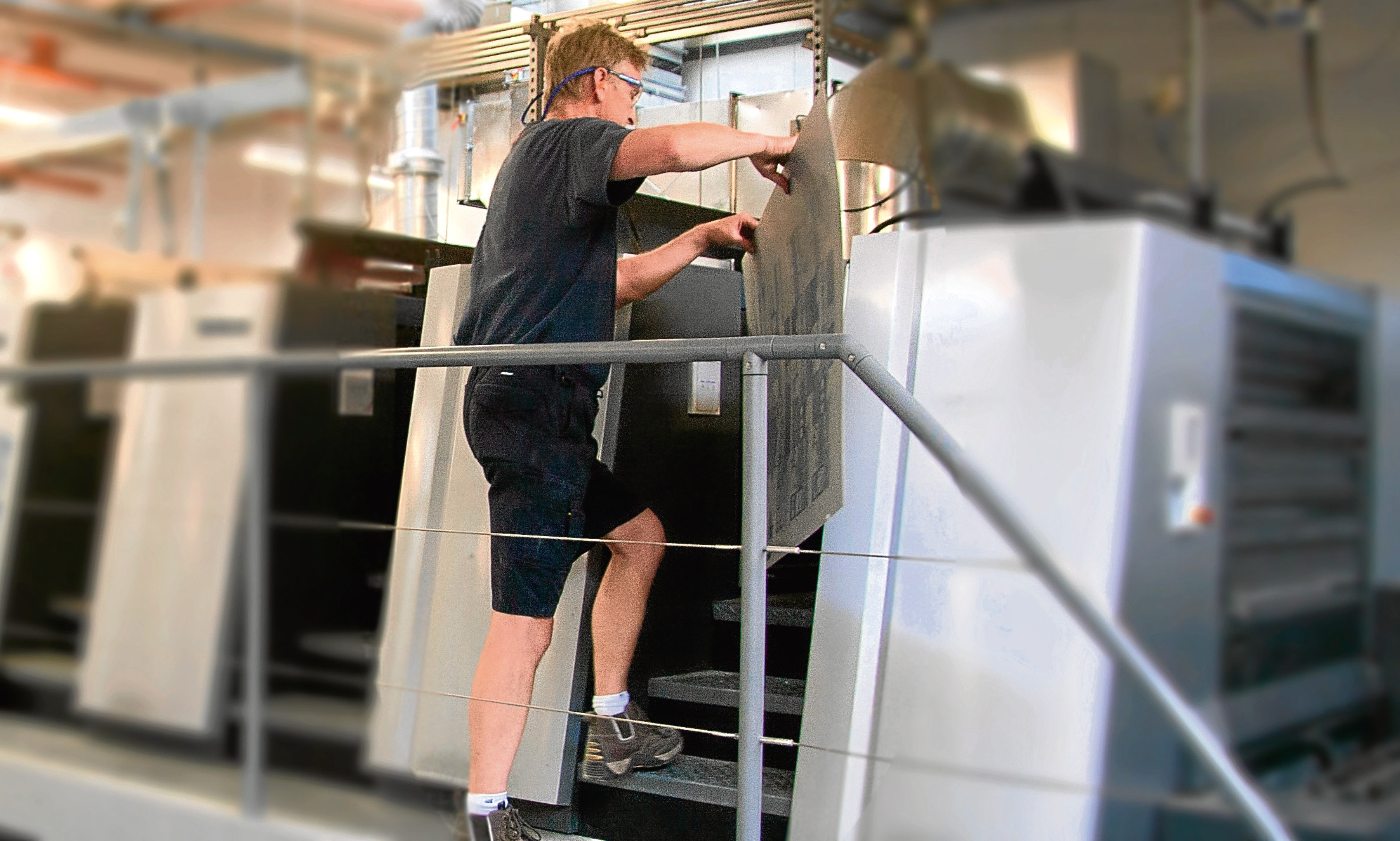 A Tradeprint technician puts a proof on a printing press