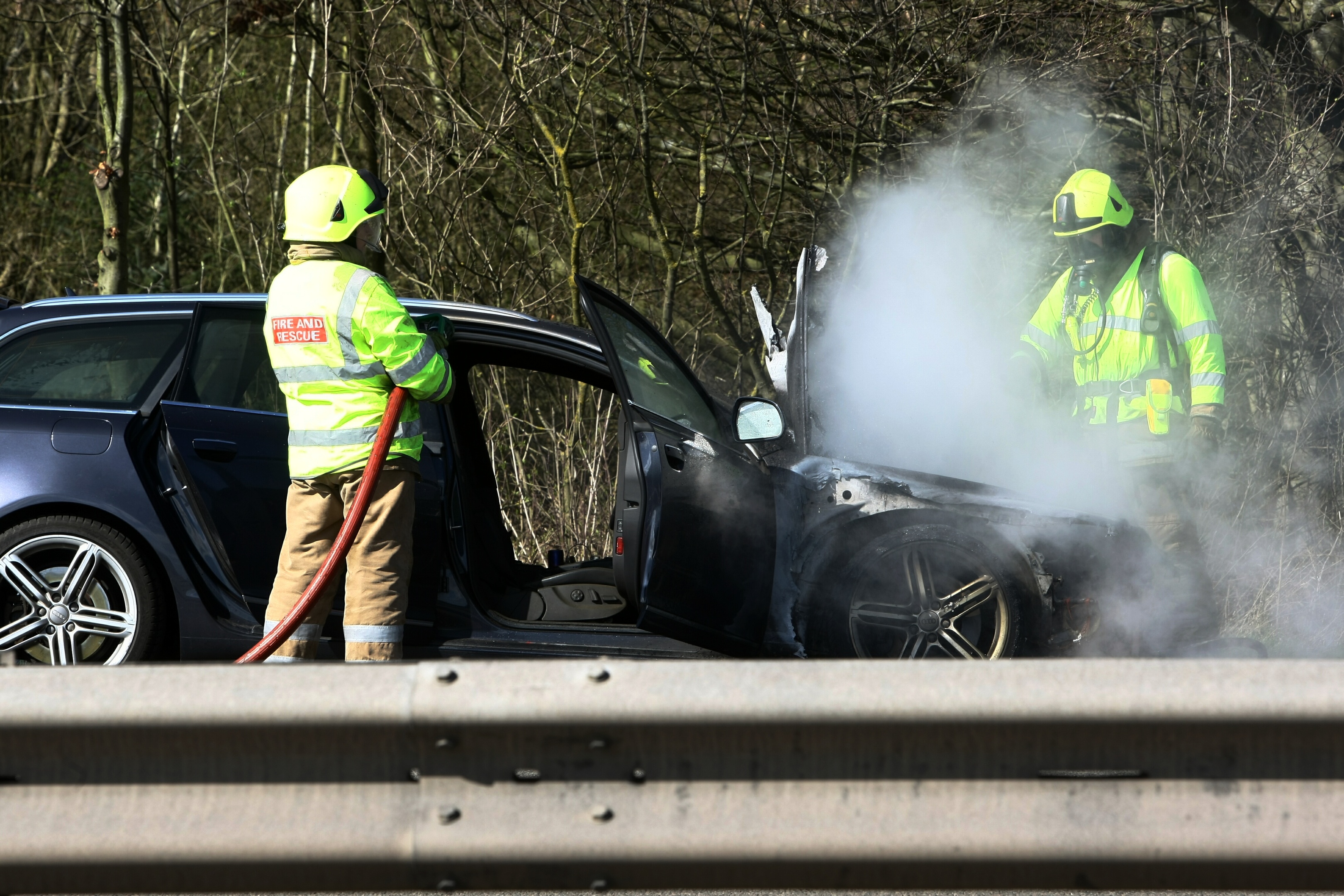 Firefighters at the burnt-out Audi.