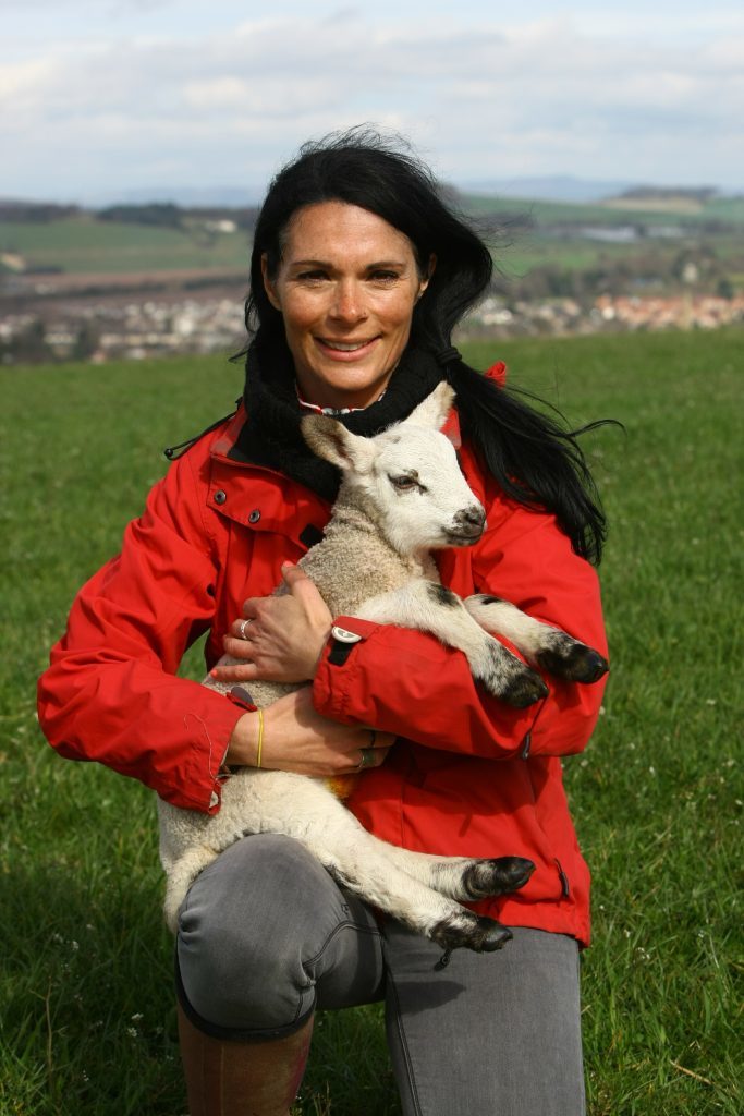 Gayle cuddling a little lamb.