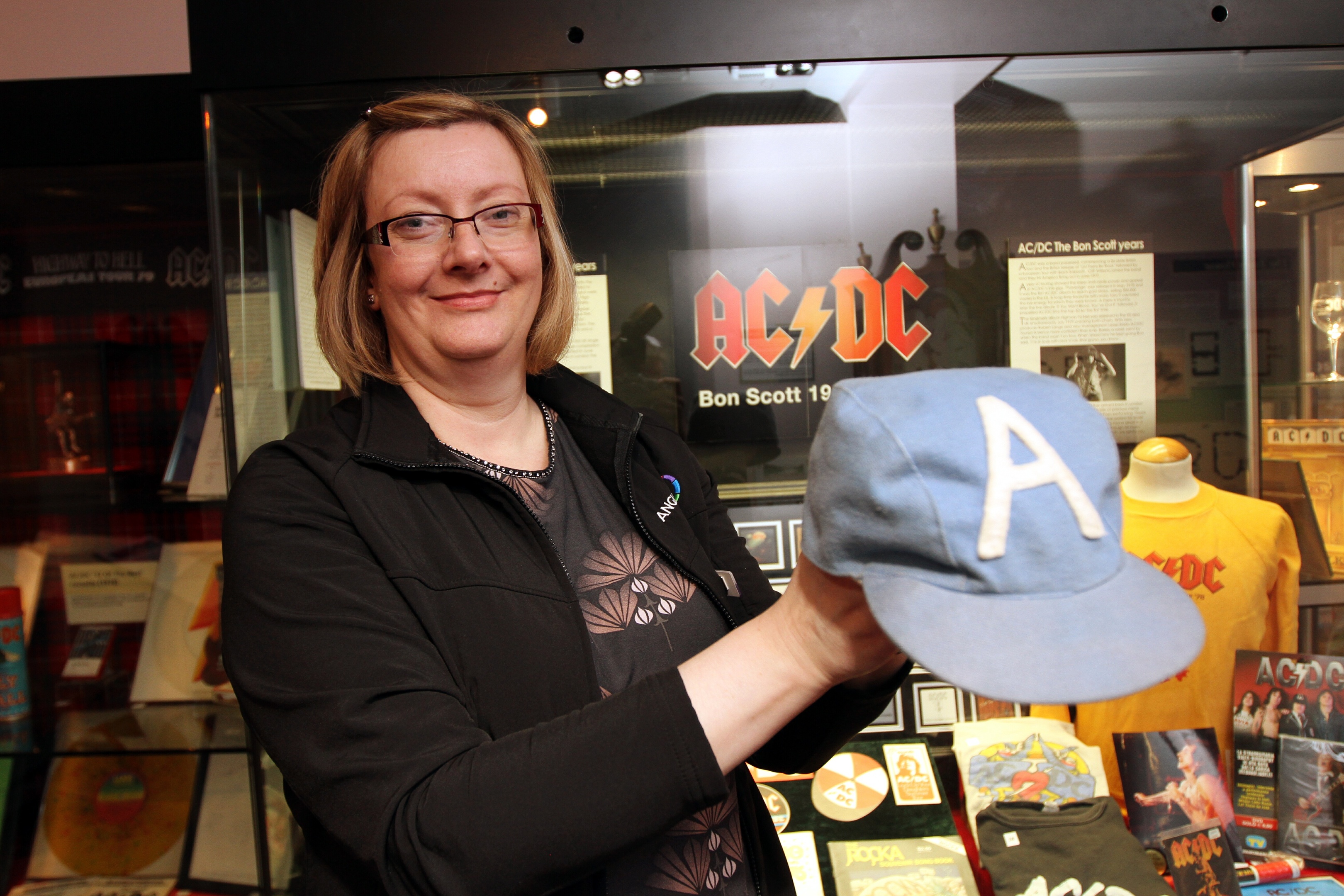 Museum officer Rachel Jackson with Angus Young's cap from 1976