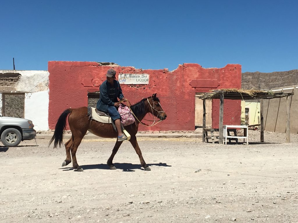 A Mexican rides past a shack in Boquillas del Carmen