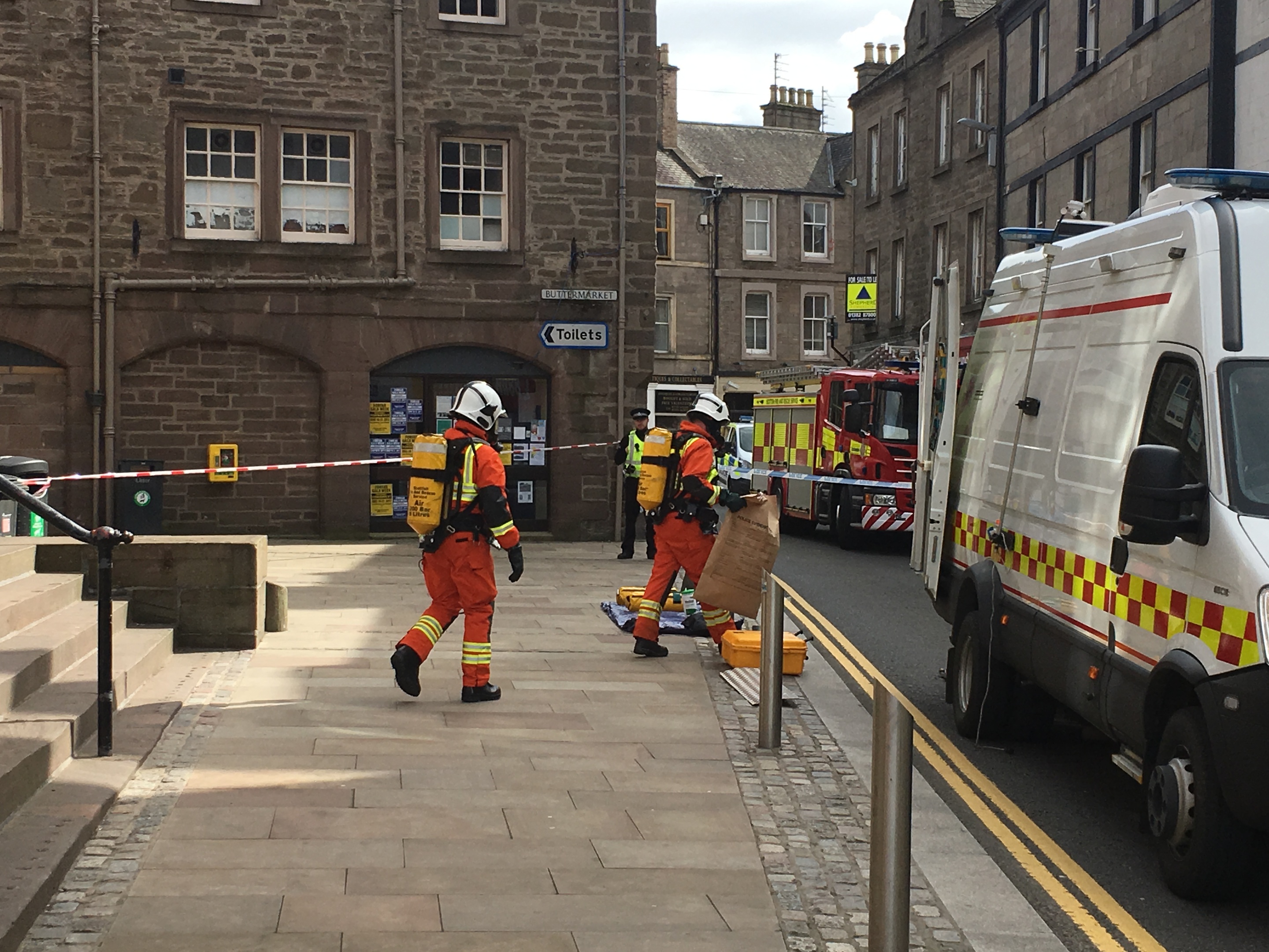 Specialist fire fighters leaving Angus Council offices with the suspect package in a brown evidence bag