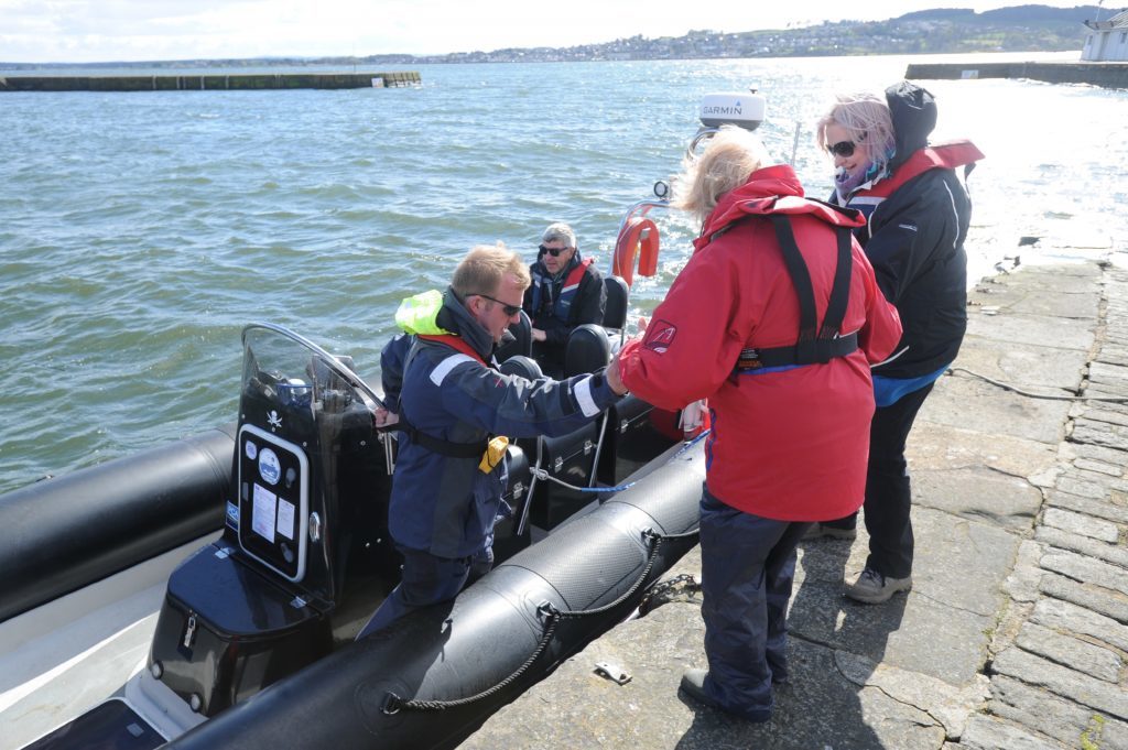 Tourists getting into the boat helped by Ian Ashton.