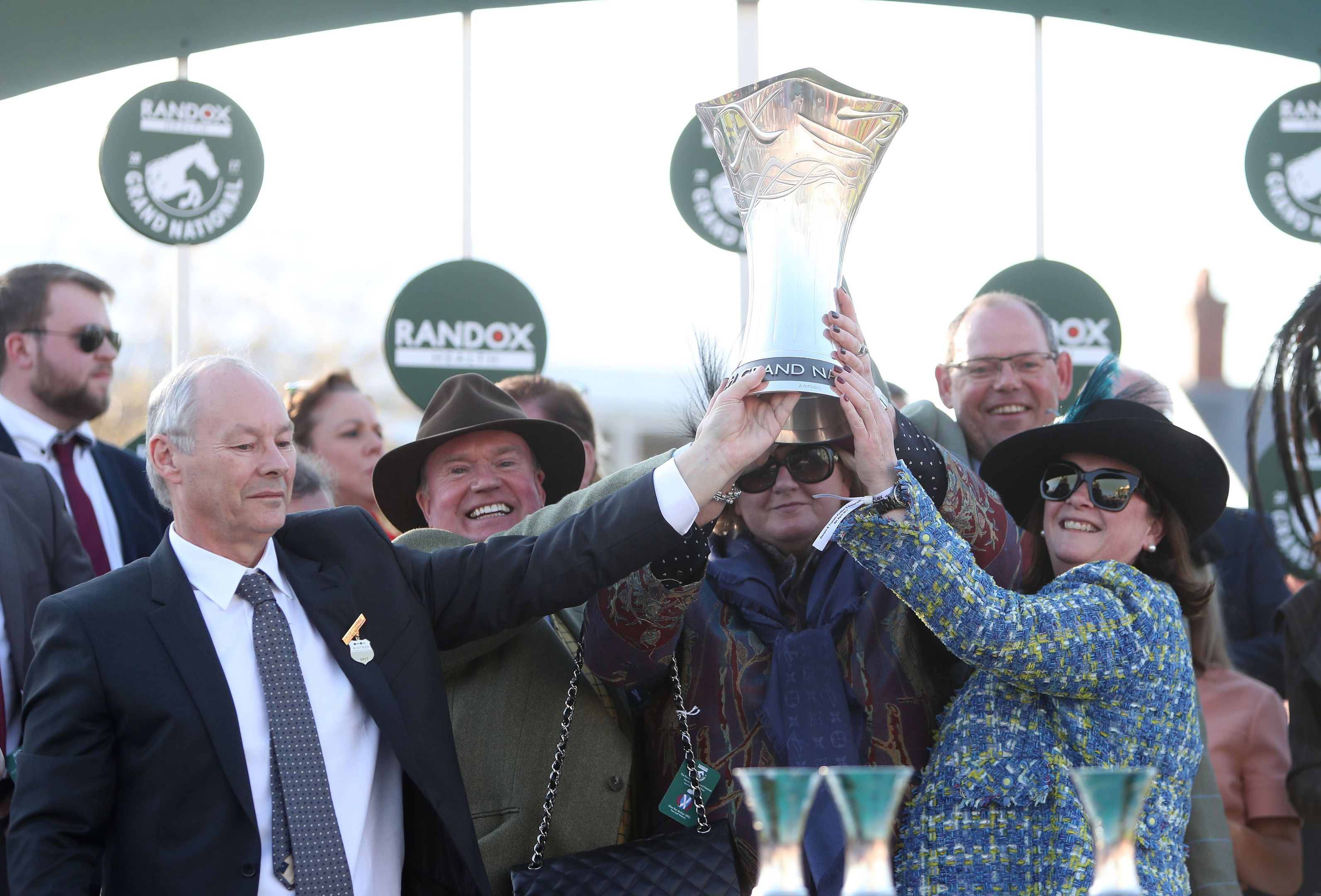 Belinda and Debs lift the trophy with husbands Colin (left) and Fraser (back, right).