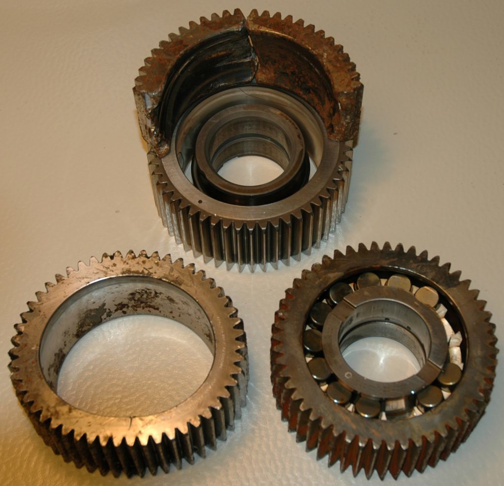 Recovered parts from the 2nd stage planet gear. Parts of the failed gear placed on top of a sample gear. Photo AIBN