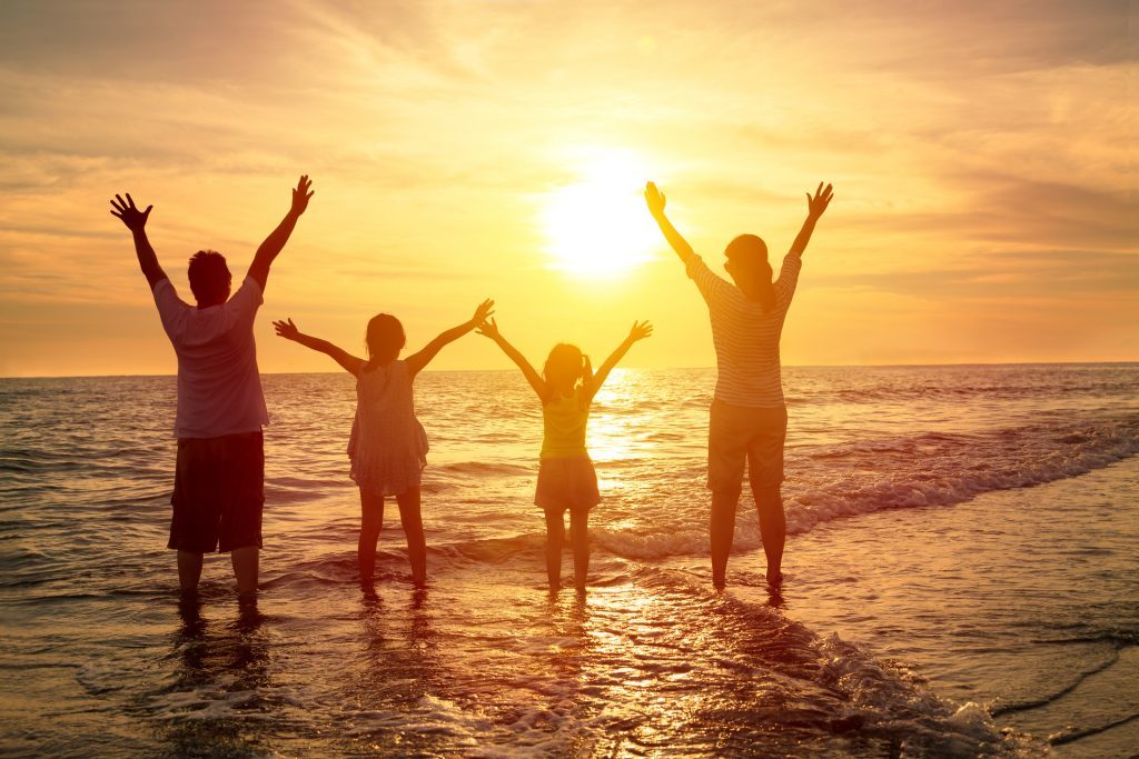 happy family watching the sunset on the beach