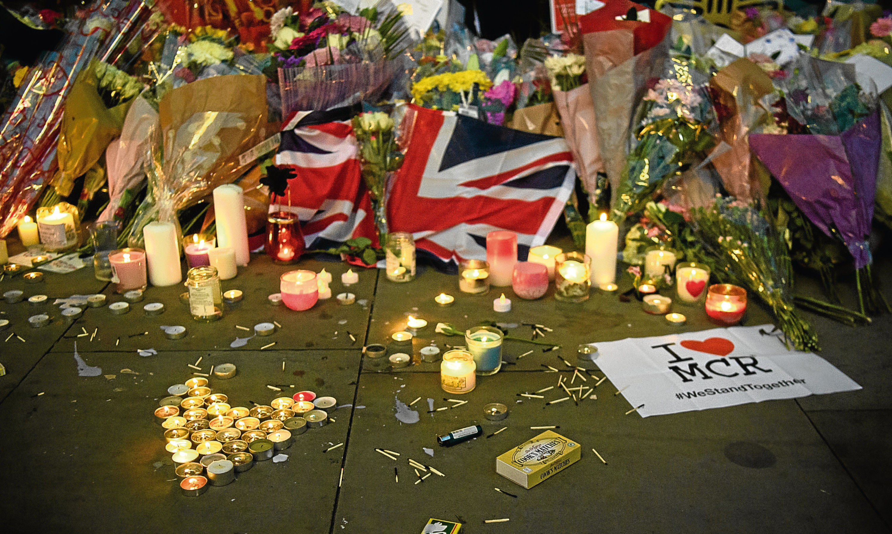 Candles and floral tributes are seen after a vigil outside Manchester Town Hall in the aftermath of the attack on Manchester Arena.