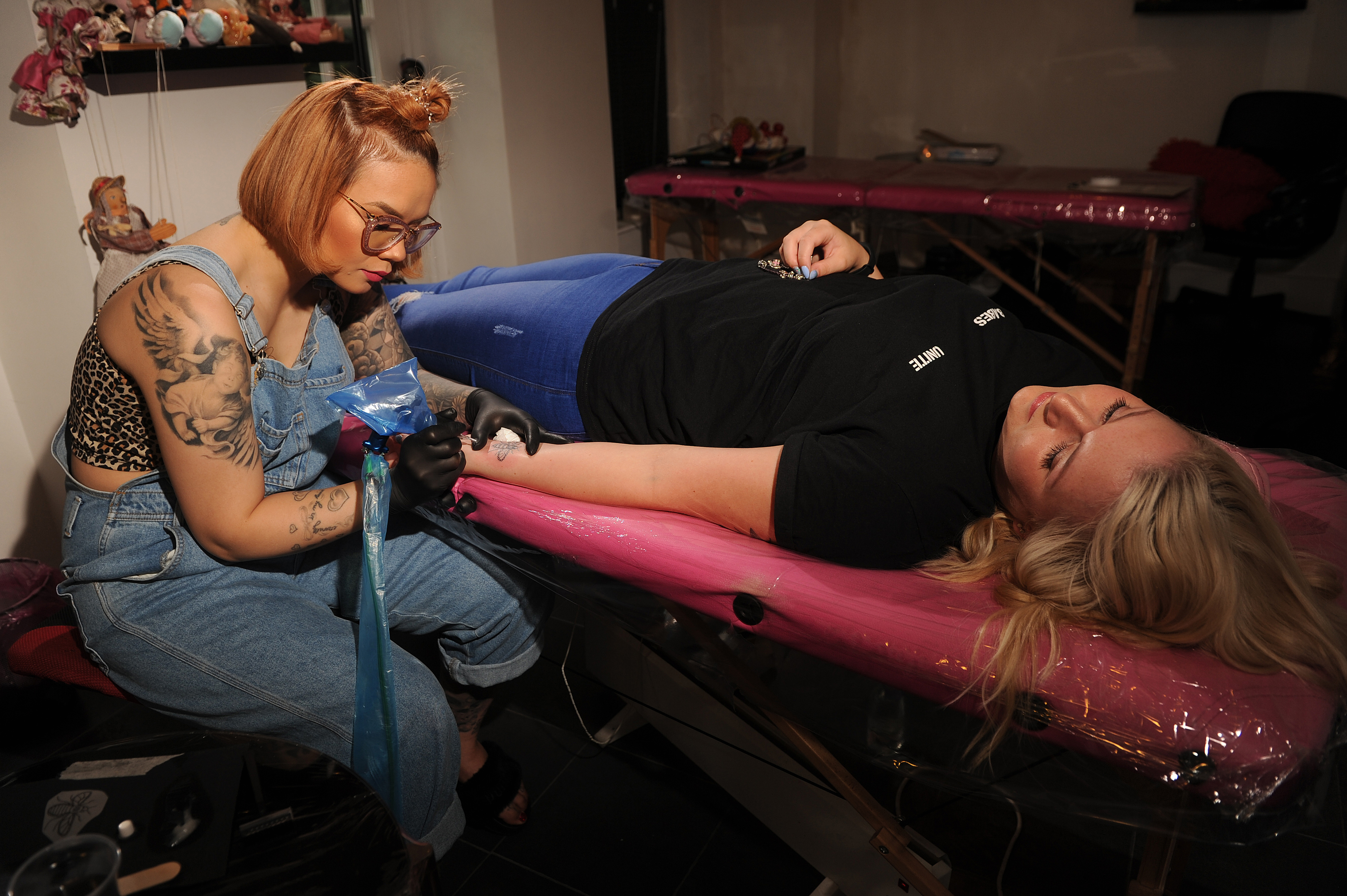 Hue Nguyen, left,  creating a Manchester Bee tattoo on Natalie McAdam's arm at Hue in Dundee,