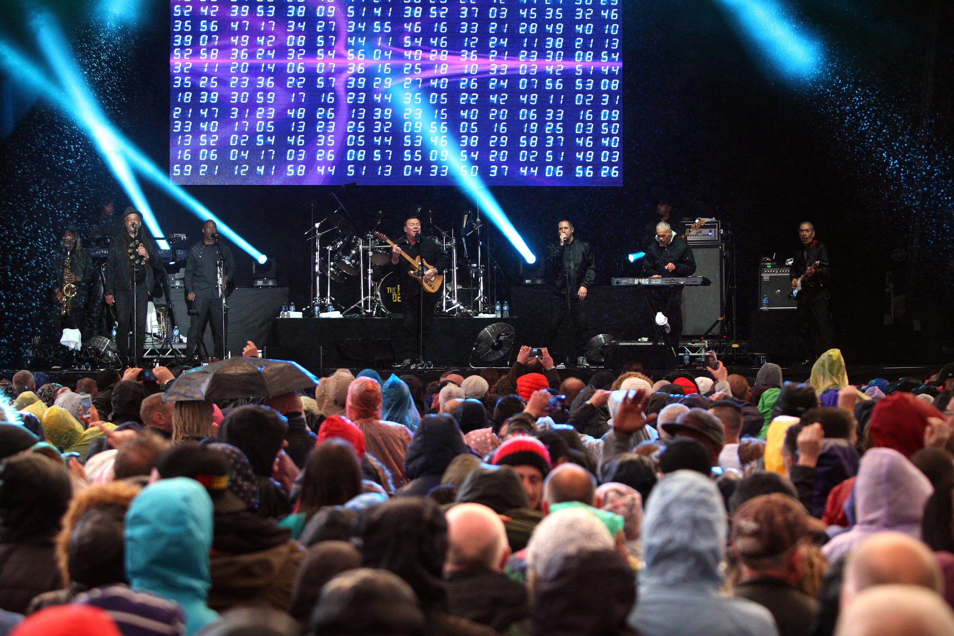 UB40 on stage as fans enjoying the show in rain and shine.