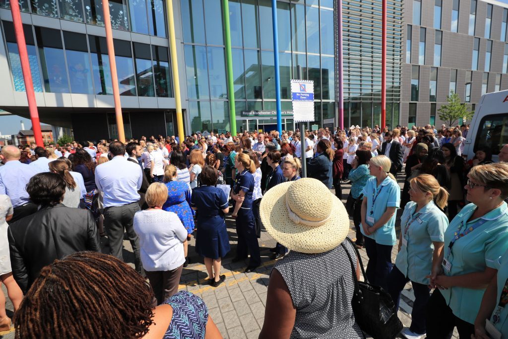 People observe a minute's silence outside the Royal Manchester Children's Hospital to mark the victims of this week's terror attack in the city.