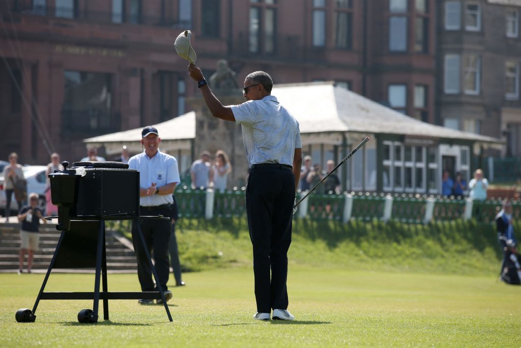 Former US president Barack Obama raises his hat after teeing off at the first hole at St Andrews.