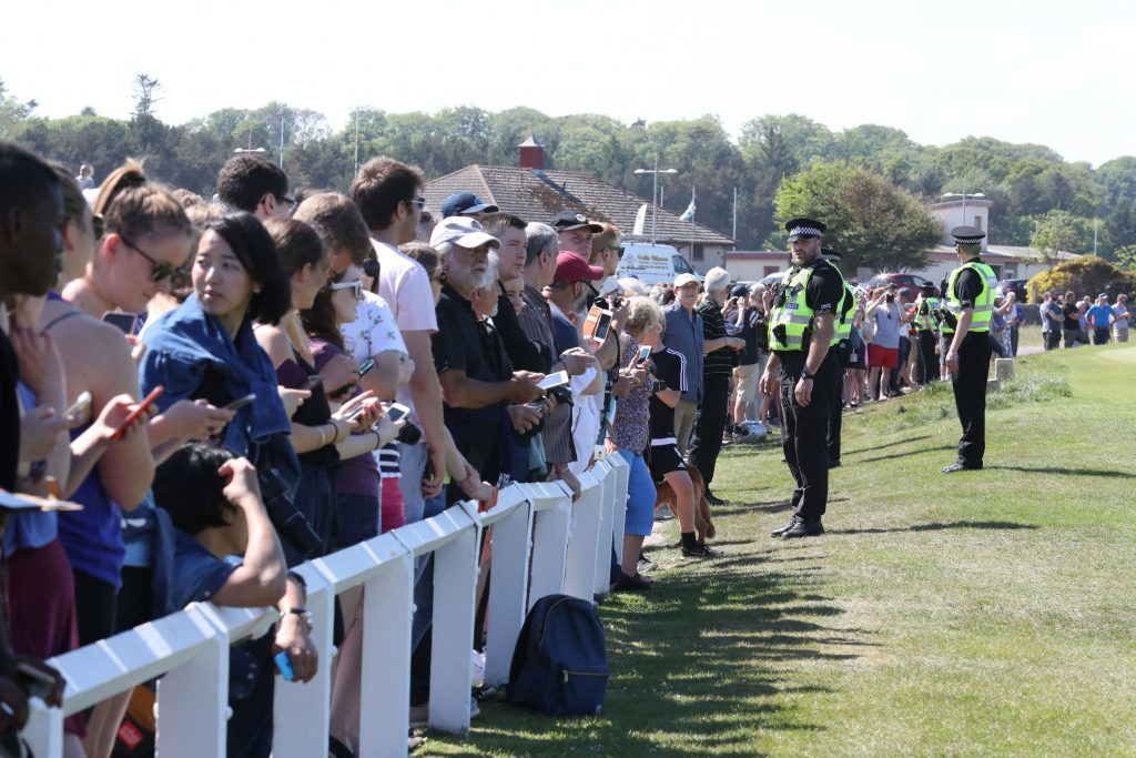 Security in front of spectators watching former US president Barack Obama.